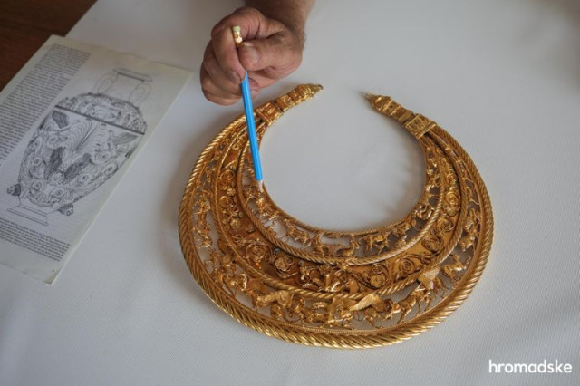 Дослідник скіфської доби Юрій Болтрик показує деталі композиції пекторалі, знайденої археологом Борисом Мозолевським у кургані Товста могила